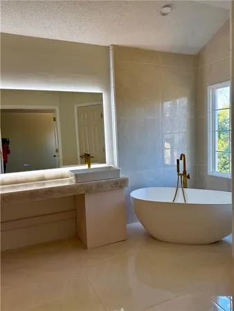 a living room with bathroom sink and mirror