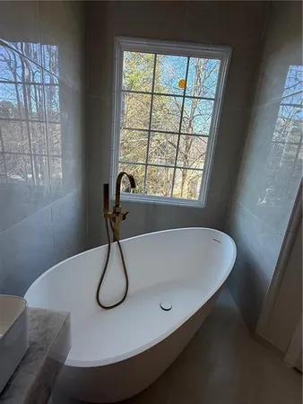 a bath tub sitting in a bathroom next to a window