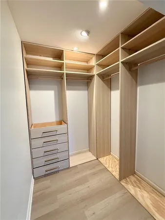 a view of walk in closet with empty racks