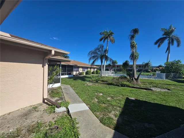 a view of a house with backyard and a tree