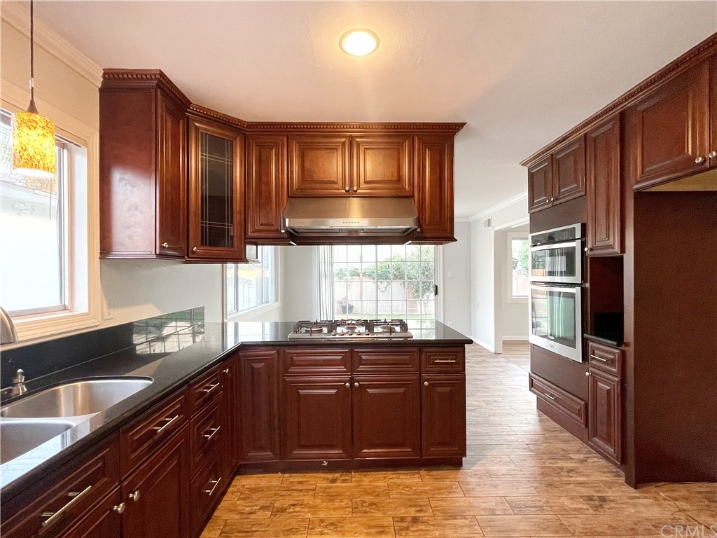 a kitchen with granite countertop wooden cabinets and stainless steel appliances