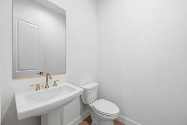 a bathroom with a sink a toilet and a mirror