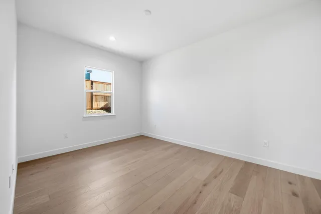 an empty room with a wooden floor and a window