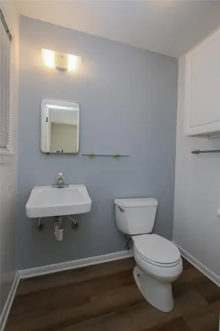 a bathroom with a toilet a sink and mirror