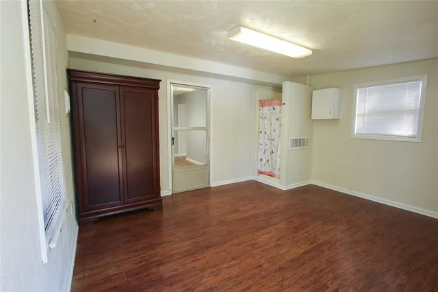 an empty room with wooden floor and closet