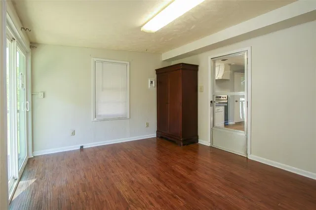 an empty room with wooden floor and closet