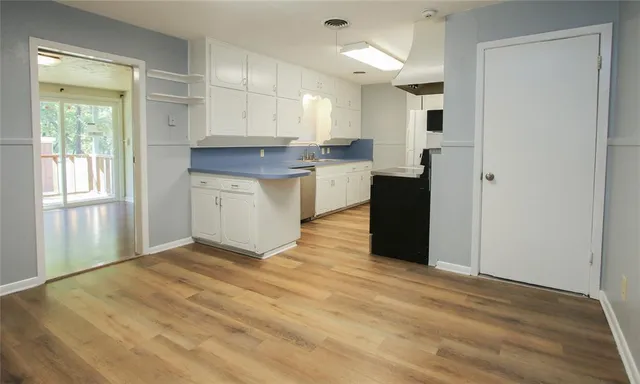 a view of a kitchen with white cabinets and a refrigerator