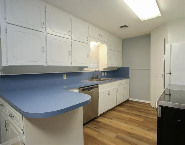 a kitchen with granite countertop a sink a stove and cabinets