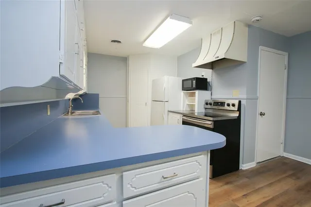 a kitchen with kitchen island a counter space a stove and a refrigerator