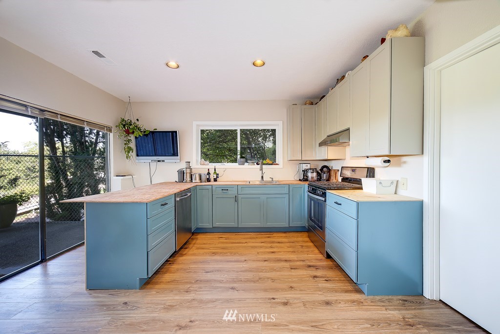 8438 Tillicum Road Southwest Seattle, WA 98136 - Photo 19 of 22 a large kitchen with stainless steel appliances kitchen island a large counter top and a stove