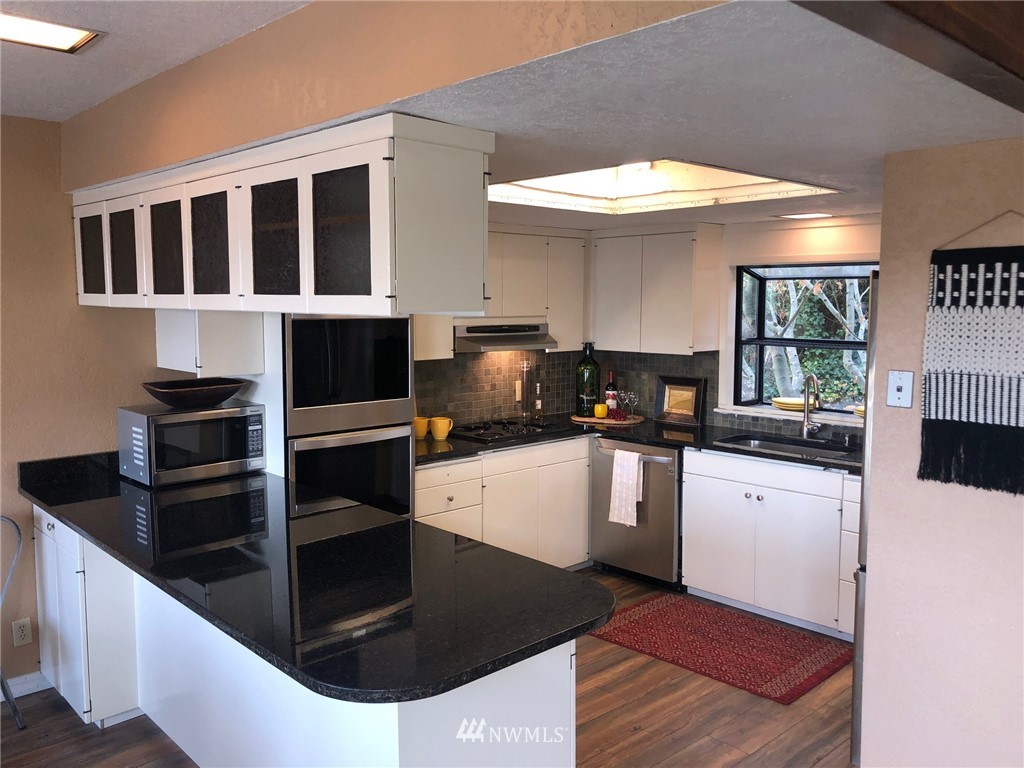 8438 Tillicum Road Southwest Seattle, WA 98136 - Photo 9 of 22 a kitchen with stainless steel appliances kitchen island granite countertop a stove and a sink