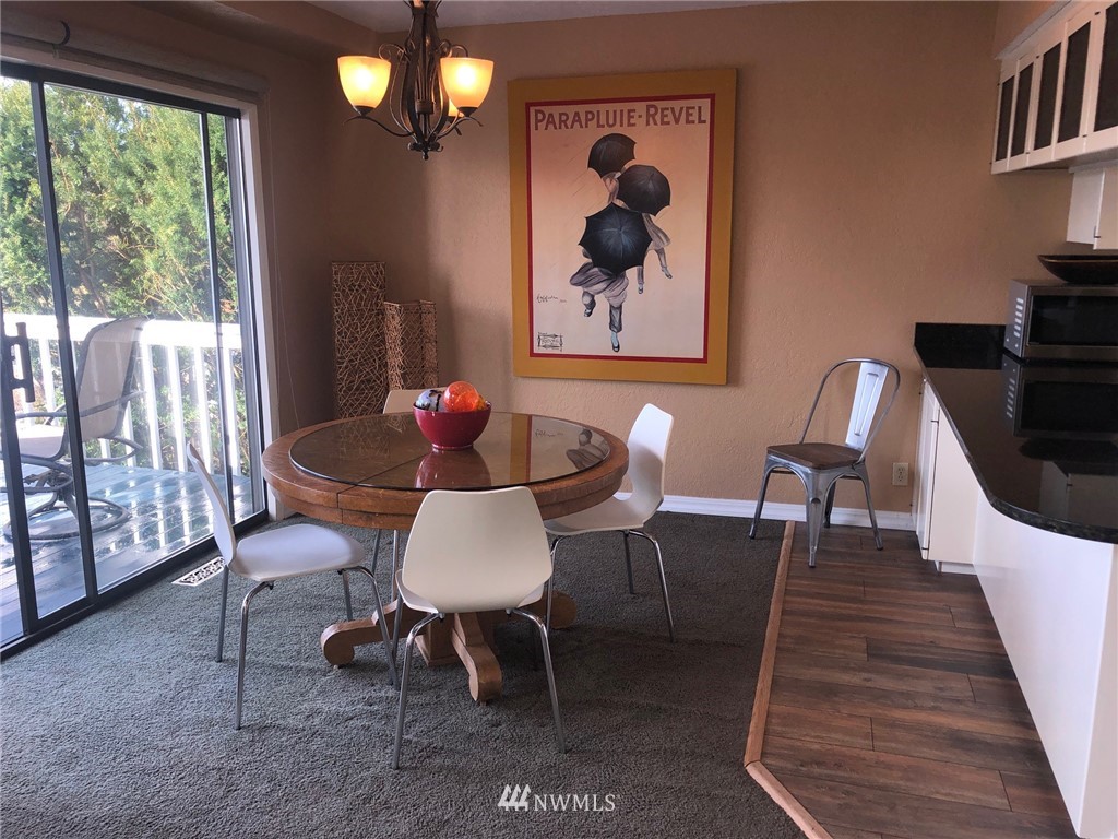 8438 Tillicum Road Southwest Seattle, WA 98136 - Photo 10 of 22 a dining room with furniture a rug and wooden floor