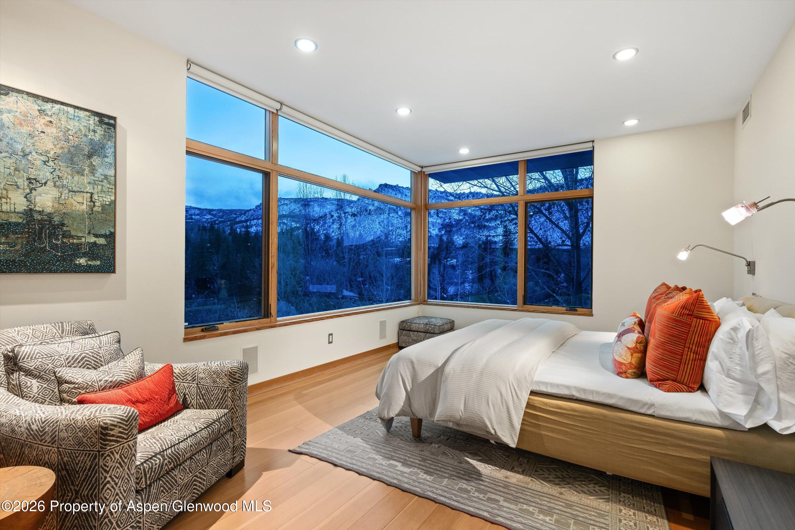8389 Upper River Road Woody Creek, CO 81656 - Photo 15 of 27 a bedroom with furniture and a large window