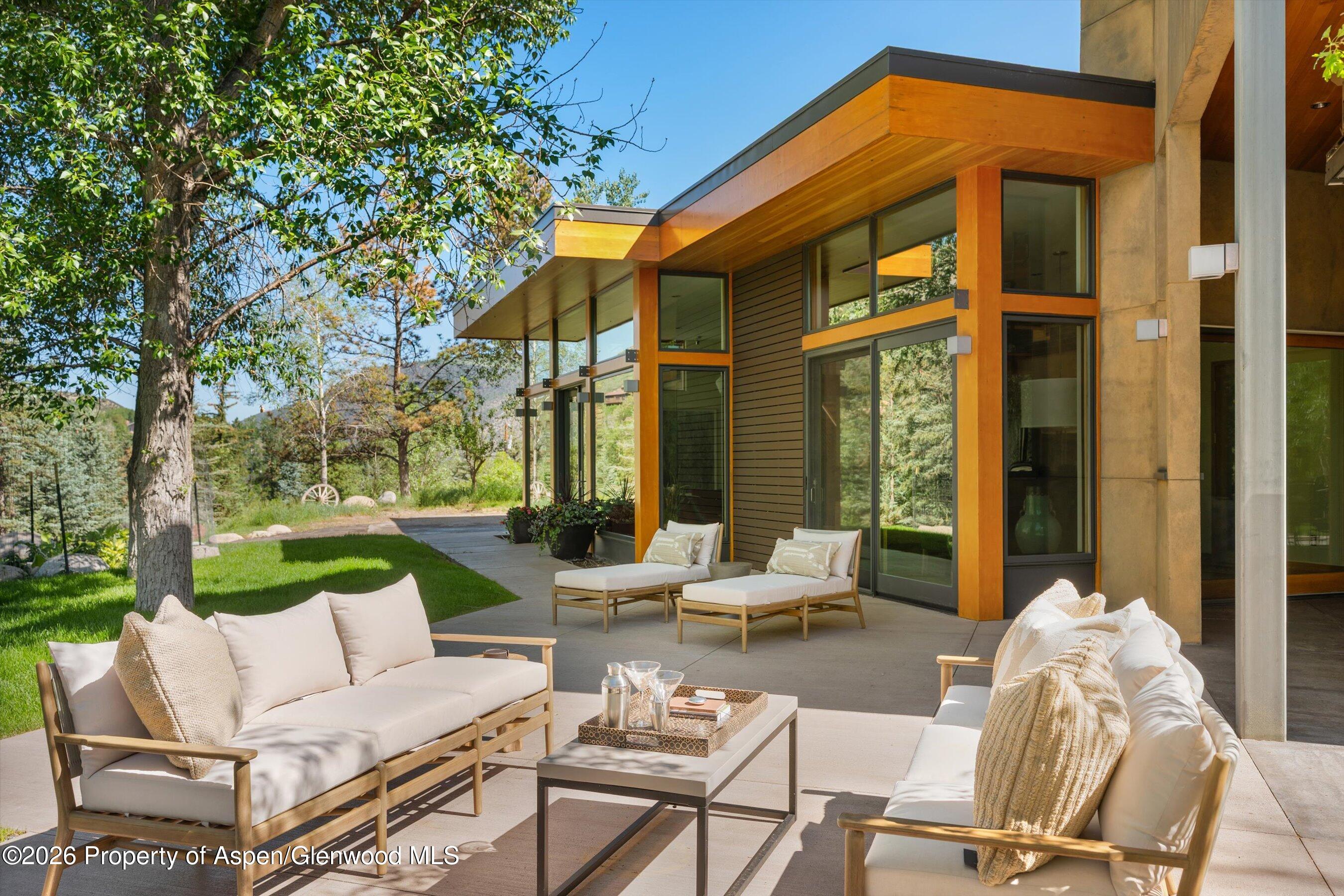 8389 Upper River Road Woody Creek, CO 81656 - Photo 26 of 27 a view of a patio with couches table and chairs and potted plants
