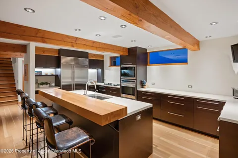 a kitchen with a sink a counter and chairs
