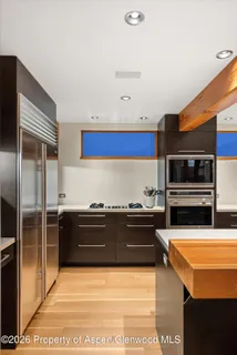 a room with wooden cabinets and stainless steel appliances