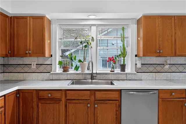 a kitchen with stainless steel appliances wooden cabinets a sink and a window