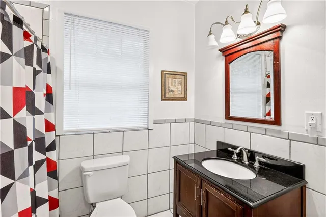 a bathroom with a sink vanity mirror and toilet
