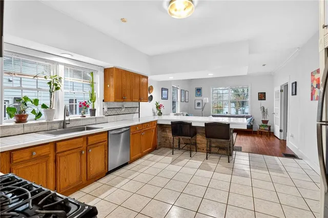 a kitchen with stainless steel appliances a sink counter space and a window