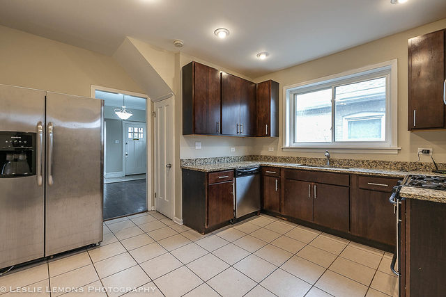 5331 West Addison Street Chicago, IL 60641 - Photo 12 of 32 a kitchen with stainless steel appliances granite countertop a refrigerator and a sink