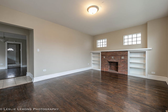 5331 West Addison Street Chicago, IL 60641 - Photo 4 of 32 an empty room with wooden floor fireplace and windows