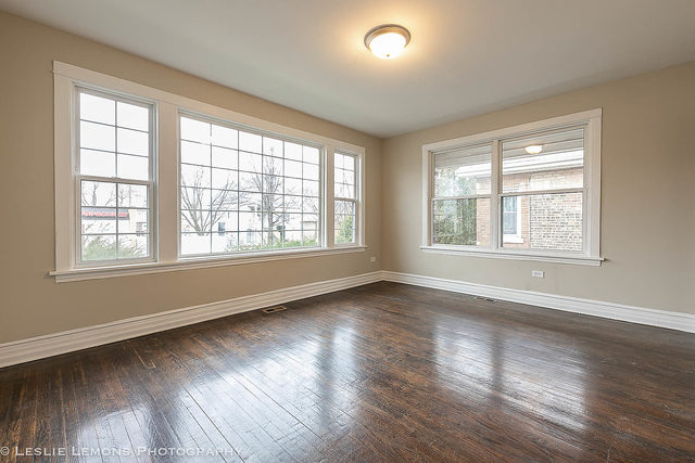 5331 West Addison Street Chicago, IL 60641 - Photo 5 of 32 a view of an empty room with wooden floor and a window