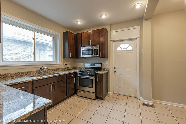 5331 West Addison Street Chicago, IL 60641 - Photo 9 of 32 a kitchen with stainless steel appliances granite countertop a stove a sink and a refrigerator