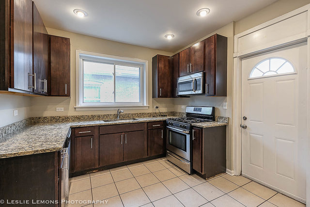 5331 West Addison Street Chicago, IL 60641 - Photo 10 of 32 a kitchen with stainless steel appliances granite countertop a stove sink and cabinets