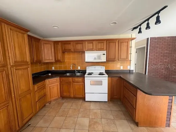 a kitchen with a stove sink and cabinets