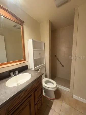 a bathroom with a granite countertop sink toilet and shower