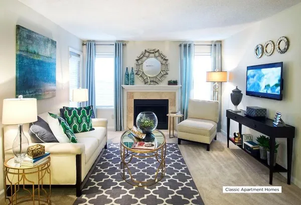 a living room with furniture a rug a fireplace and a window