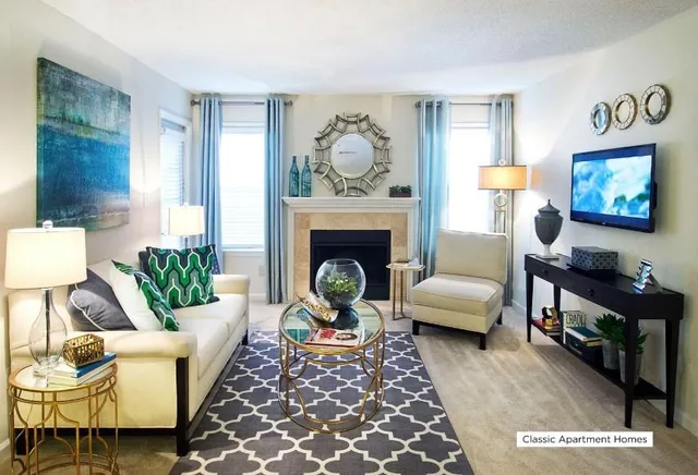 a living room with furniture a rug a fireplace and a window