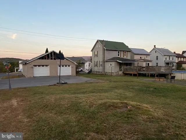 a view of a house with a big yard and large trees