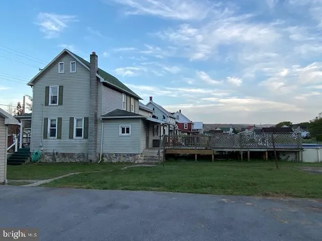 a view of a house with a big yard and a large tree