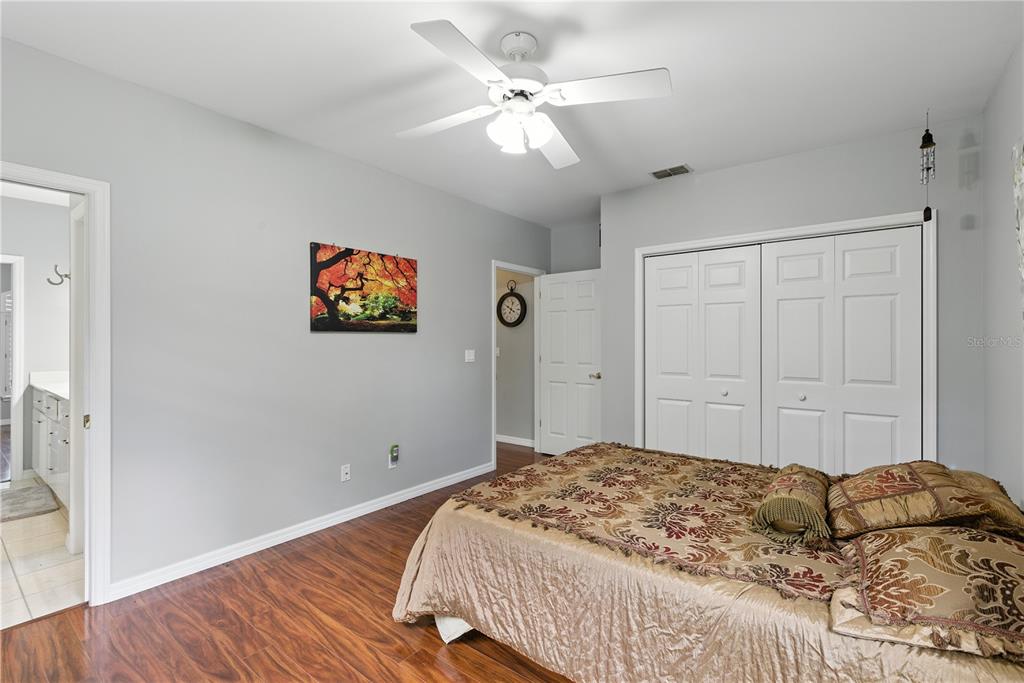 36641 Blanton Road Dade City, FL 33523 - Photo 18 of 76 a bedroom with a large bed and a chandelier fan