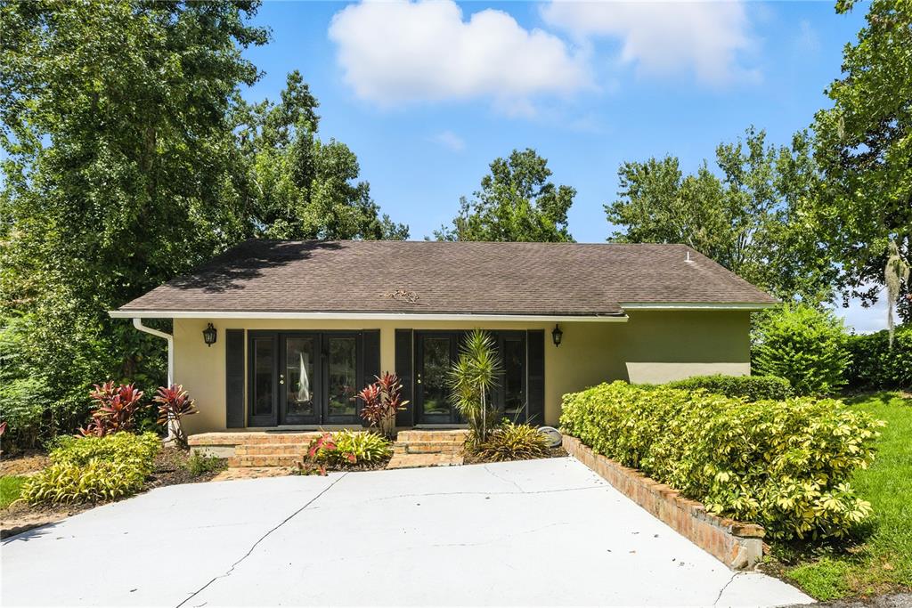 36641 Blanton Road Dade City, FL 33523 - Photo 39 of 76 a view of a house with potted plants and a large tree