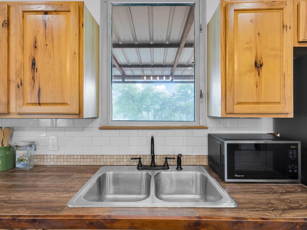 830 Louis Scherer Road Weatherford, TX 76088 - Photo 12 of 36 a kitchen with granite countertop a sink and a window
