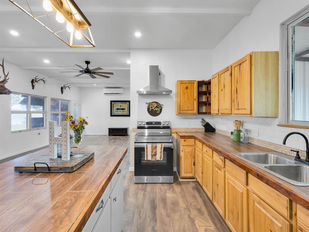 830 Louis Scherer Road Weatherford, TX 76088 - Photo 13 of 36 a kitchen with stainless steel appliances granite countertop a sink stove and wooden cabinets