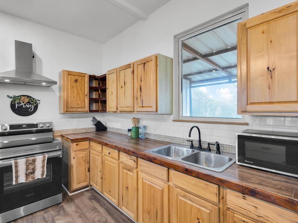 830 Louis Scherer Road Weatherford, TX 76088 - Photo 14 of 36 a kitchen with stainless steel appliances a stove a sink and a microwave
