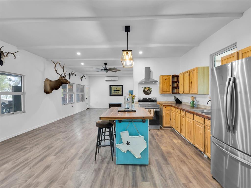 830 Louis Scherer Road Weatherford, TX 76088 - Photo 15 of 36 a kitchen with stainless steel appliances granite countertop a refrigerator a sink dishwasher a stove and white countertops with wooden floor