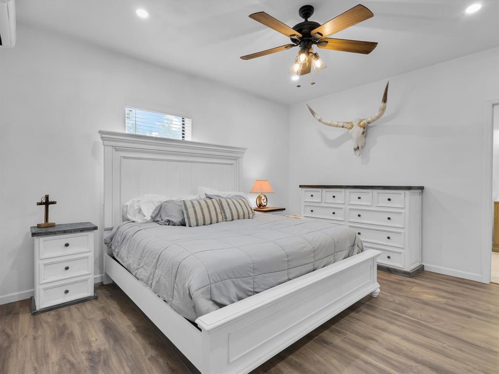 830 Louis Scherer Road Weatherford, TX 76088 - Photo 21 of 36 a bedroom with a bed and a chandelier