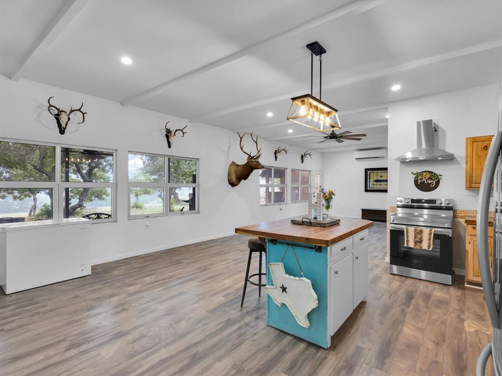 830 Louis Scherer Road Weatherford, TX 76088 - Photo 7 of 36 a kitchen with stainless steel appliances granite countertop a stove oven and a wooden floors