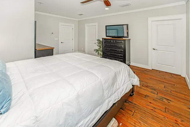 a bedroom with a bed and wooden floor