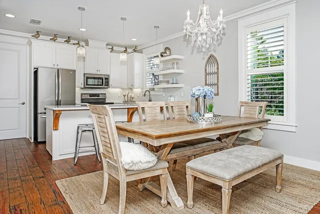 a dining table with chairs and kitchen view