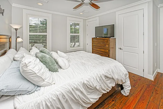 a bedroom with a bed flat screen tv and windows