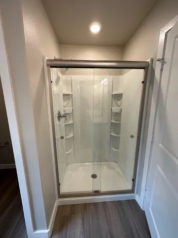 a bathroom with a glass door shower and vanity