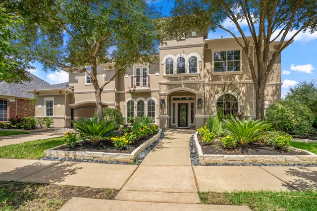 a front view of a house with a yard and potted plants
