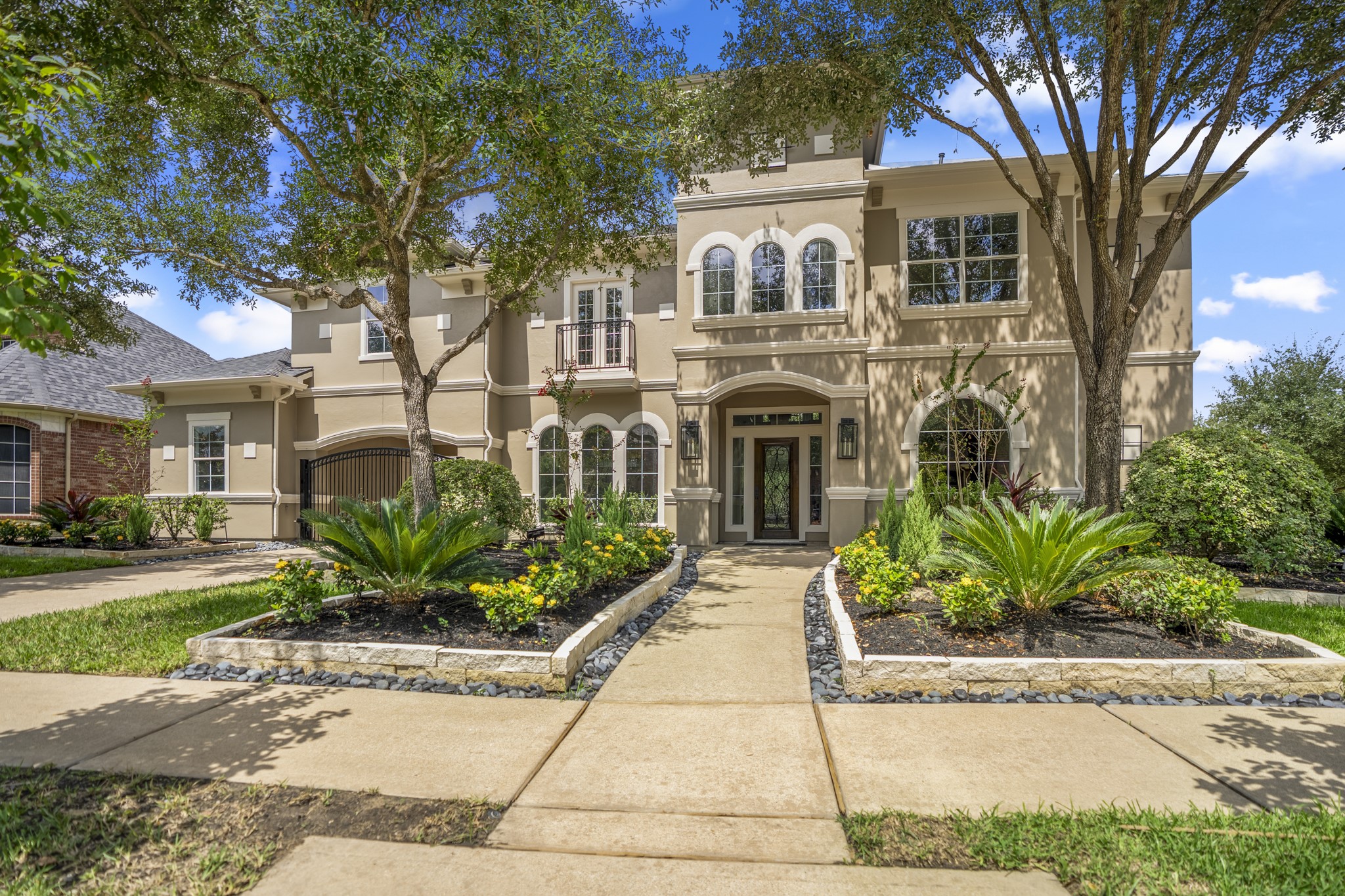 a front view of a house with a yard and potted plants