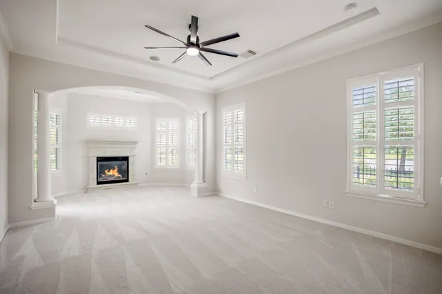 a view of an empty room with a window and a fireplace