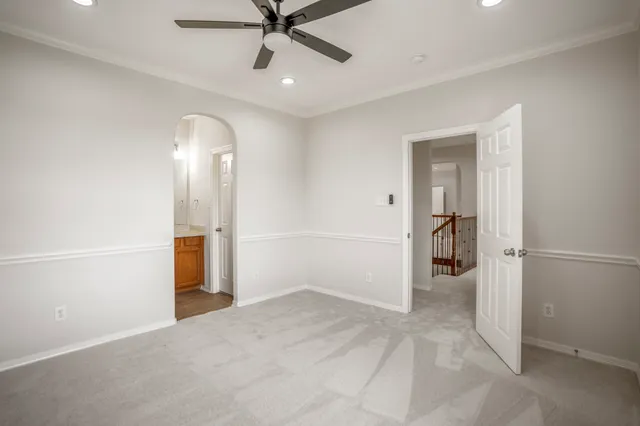 an empty room with closet and a ceiling fan